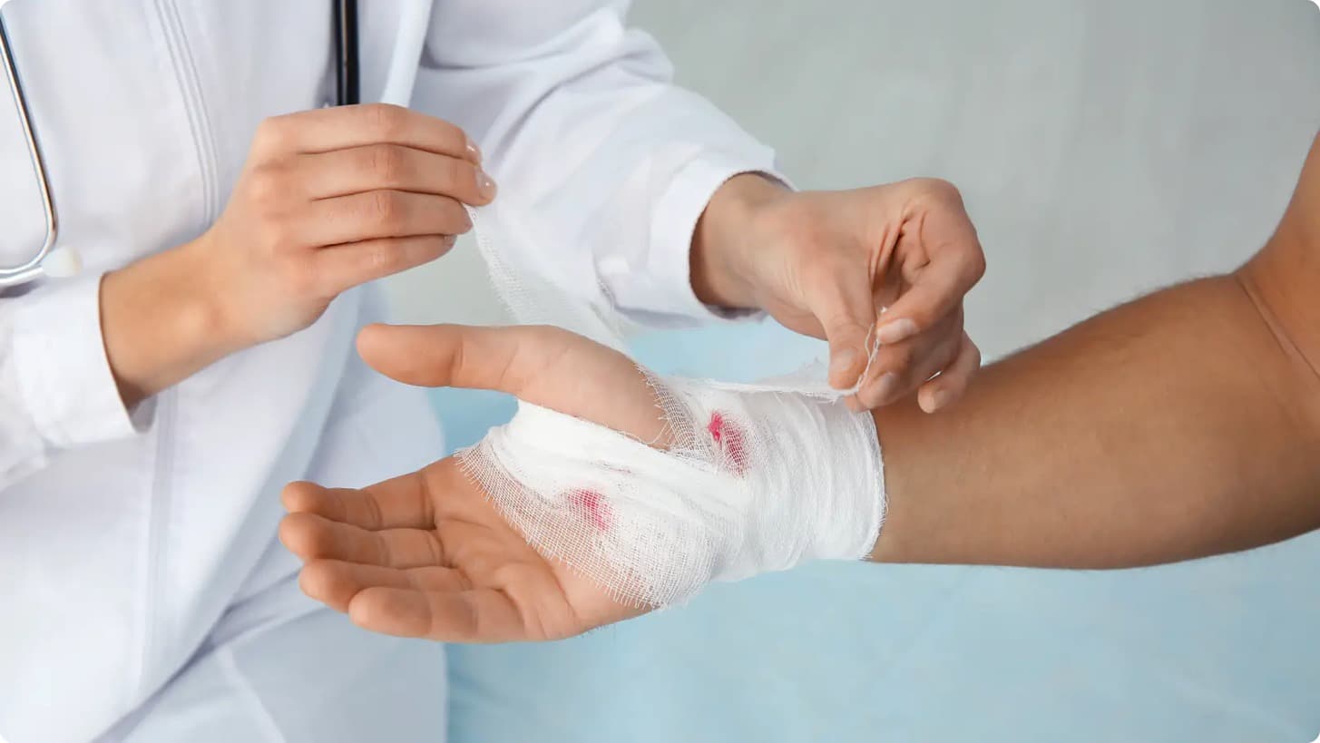 Nurse bandaging a patient's hand
